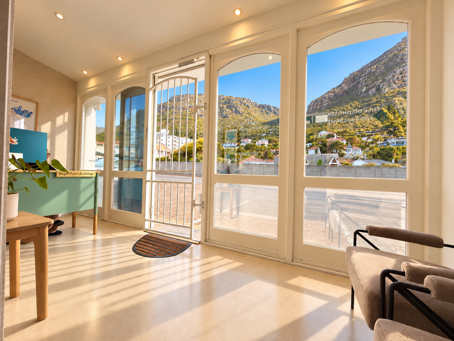 Sunlit reception at Megan Paton Audiology, with views of Muizenberg mountain through the front windows